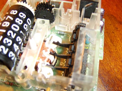 1996 Mercury Grand Marquis - The internal workings of a vehicle's odometer, showing the numbered rollers and electronic components.