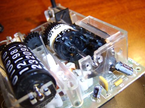 1996 Mercury Grand Marquis - The internal workings of an odometer, showing the numbered rollers and gears used to track mileage.