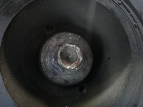 1993 Ford Taurus - Close-up view of a bolt head inside a dark, circular housing, possibly part of machinery.
