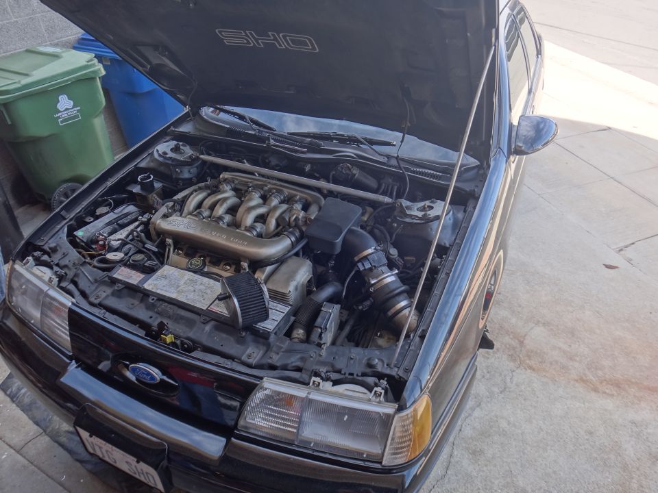 Black 1991 Ford Taurus SHO engine bay with hood open, showing V8 engine and intake