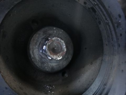 1993 Ford Taurus - Bolt head on a dark, circular component, likely part of an engine or machinery.