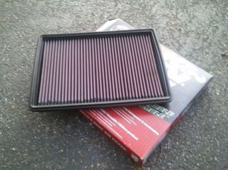 1996 Ford Bronco - A K&N air filter is shown resting on its packaging, which features the SuperMotors logo.