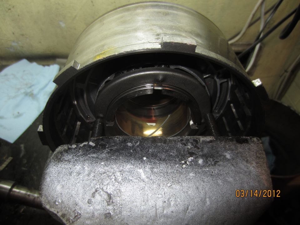 Transmission component held in a vise, showing internal gears and springs