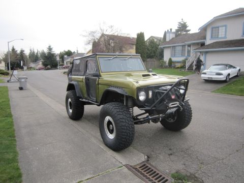 1974 Ford Bronco - Modified 1974 Ford Bronco parked on a suburban street, oversized tires and a roll cage.