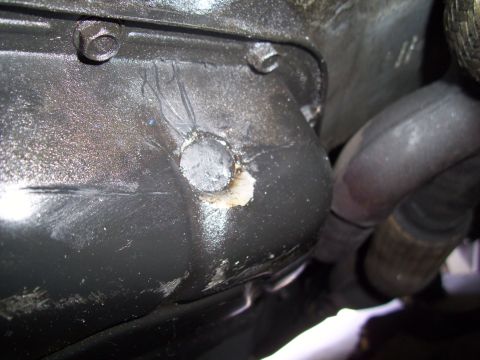 2003 Hyundai Tiburon - Close-up view of an engine oil pan, showing the drain plug area and surrounding components.