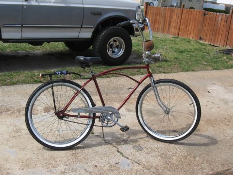 1994 Ford Bronco - Cruiser bicycle with whitewall tires and ape hanger handlebars parked in front of a pickup truck.