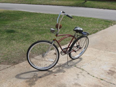 1994 Ford Bronco - A classic red cruiser bicycle with whitewall tires and chrome handlebars is parked on a concrete driveway.