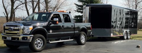 2006 Ford F-350 - This black Ford F-350 Super Duty truck is shown towing a large black trailer.