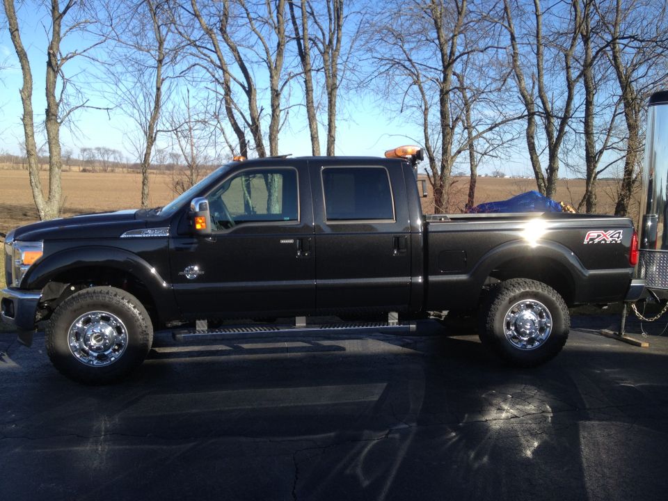Black crew cab pickup truck parked outdoors, side view. FX4 badging visible on rear fender