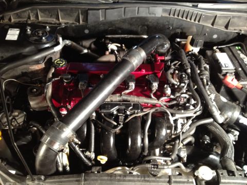 1987 Ford Bronco - Close-up view of a modified engine bay, red valve covers and a custom intake system.