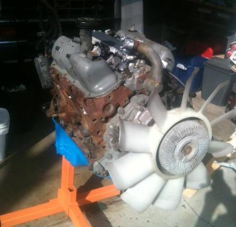 1988 Ford Bronco II - Engine assembly on an orange stand, showing various components and a large fan.