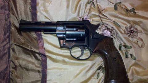 1988 Chevrolet Suburban - A black revolver with a wooden grip rests on a textured fabric surface.