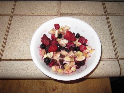 1990 Ford Bronco - A white bowl filled with strawberries, blueberries, raspberries, and banana pieces sits on a speckled countertop.