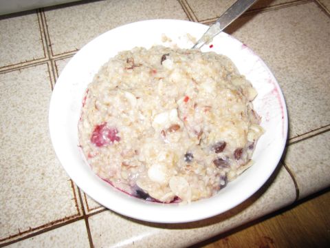 1990 Ford Bronco - A close-up of a bowl of oatmeal topped with berries and nuts, with a spoon resting in it.