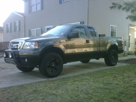 2008 Ford F-150 - This 2008 Ford F-150 pickup truck is parked in front of a house on a paved driveway.