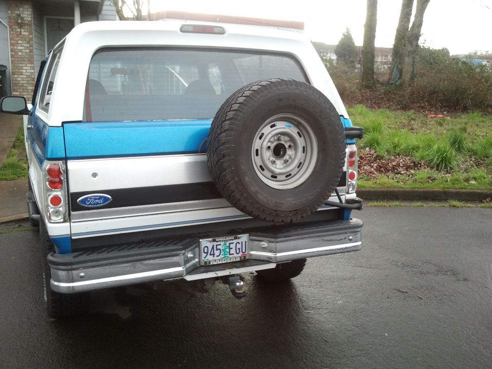 Two-tone blue and silver 1992 Ford Bronco rear view with spare tire mounted on tailgate