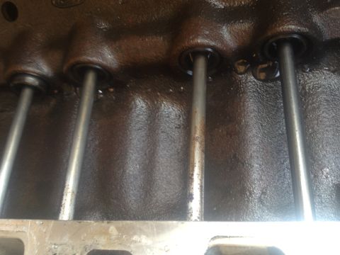 1992 Ford Bronco - Close-up view of engine pushrods within a dark, oily block, suggesting internal engine work.