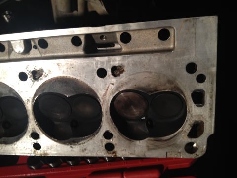 1992 Ford Bronco - Engine cylinder head showing combustion chambers and bolt holes, likely during a rebuild.