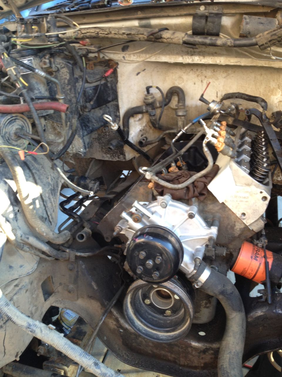 1992 Ford Bronco engine bay with a new water pump and oil filter installed