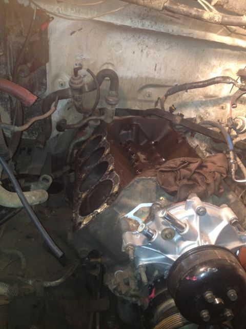 1992 Ford Bronco - Engine bay undergoing repair, showing disassembled engine parts and various hoses and wiring.