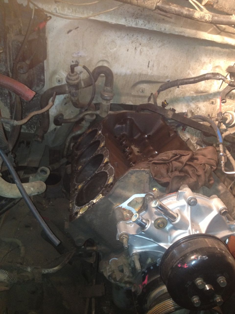 Engine bay with disassembled engine components and hoses