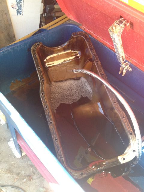 1992 Ford Bronco - Oil pan being cleaned in a parts washer tank.