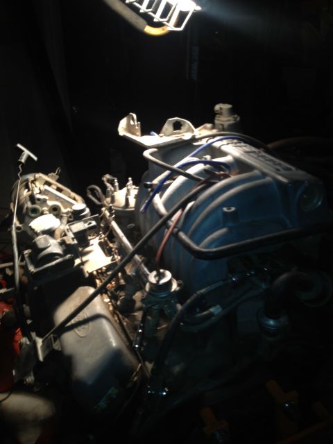 1992 Ford Bronco - Engine parts are visible under a bright work light in a dark setting.