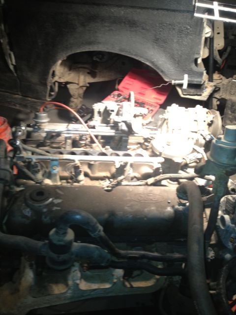 1992 Ford Bronco - Close-up of a Ford engine, likely undergoing a rebuild, with a red battery visible in the background.