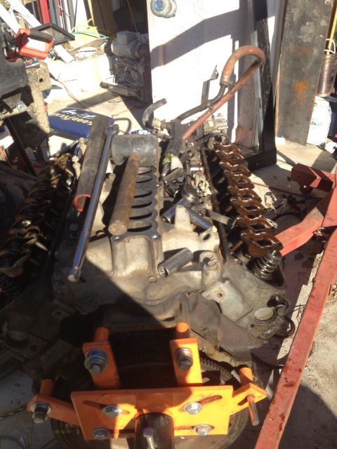 1992 Ford Bronco - Engine on an orange engine stand, appearing to be undergoing a rebuild or repair.