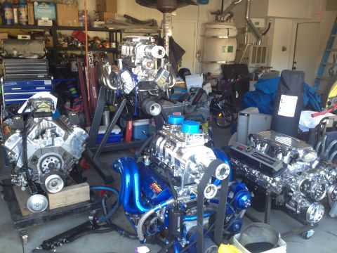 1992 Ford Bronco - Multiple custom V8 engines are displayed in a garage, some with chrome and blue finishes.