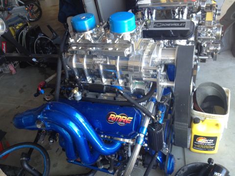 1992 Ford Bronco - A highly customized engine with a prominent supercharger and vibrant blue components sits ready for installation.