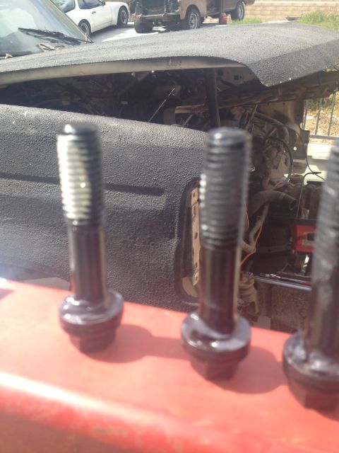 1992 Ford Bronco - Bolts are in the foreground, with a vehicle engine bay and other cars visible behind.