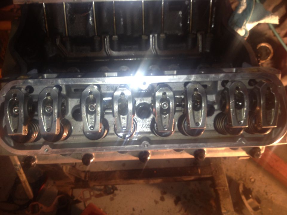 Engine valve train with rocker arms and springs visible inside a disassembled engine block