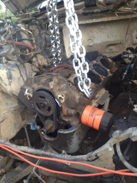 1992 Ford Bronco - Engine block and components being worked on, with chains attached for lifting.