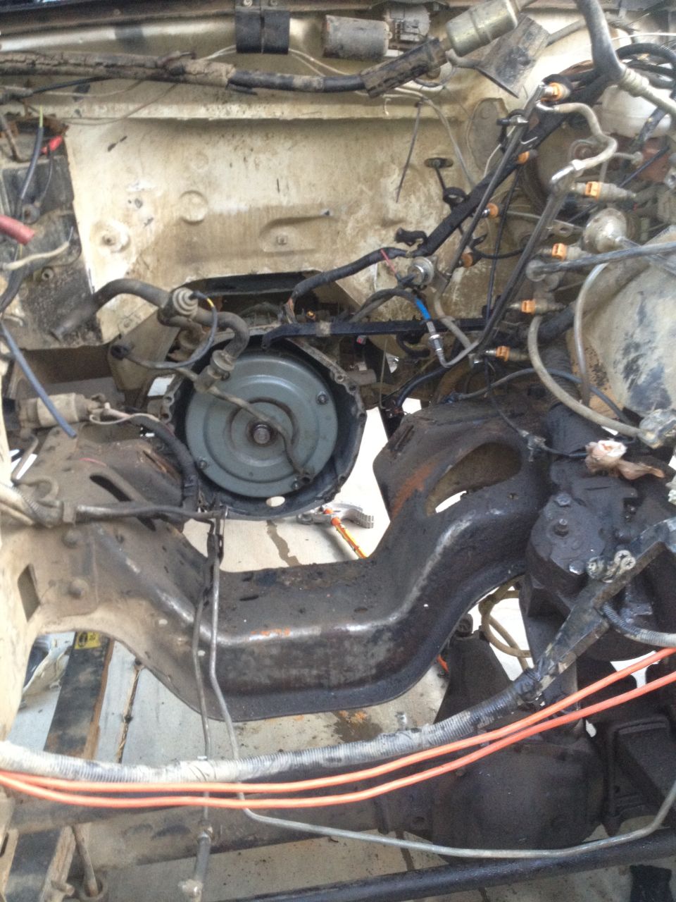 Engine bay with transmission and frame visible, undergoing rebuild