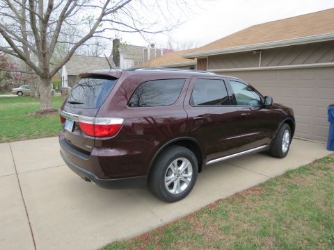 2012 Dodge Durango - The rear passenger side of a maroon SUV is shown parked on a concrete driveway.