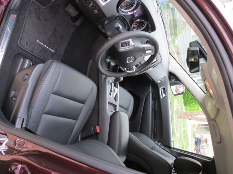 2012 Dodge Durango - The interior of a maroon SUV shows black leather seats and a detailed dashboard with a steering wheel.