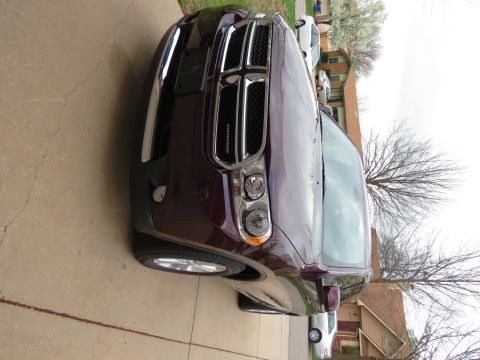 2012 Dodge Durango - This purple 2012 Dodge Durango is parked in a driveway, showing its front grille and headlights.