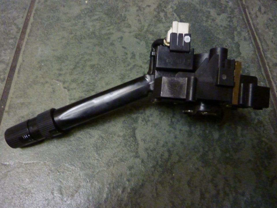 Black ignition switch assembly with wiring connector on a tiled surface