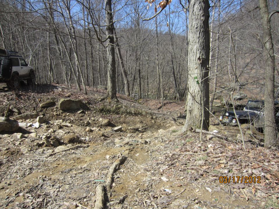 1979 Ford Bronco and another off-road vehicle on a rocky, wooded trail