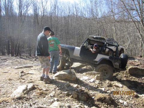 1979 Ford Bronco - A modified Jeep navigates a challenging off-road course with spectators nearby.