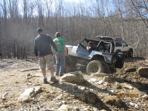 1979 Ford Bronco - Two off-road vehicles tackle a challenging rocky terrain on a sunny day.