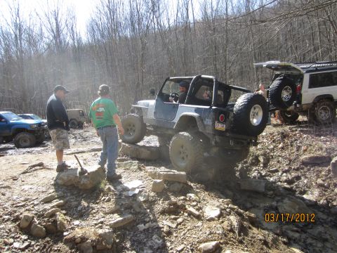 1979 Ford Bronco - Several off-road vehicles tackle a challenging rocky trail on a sunny day.