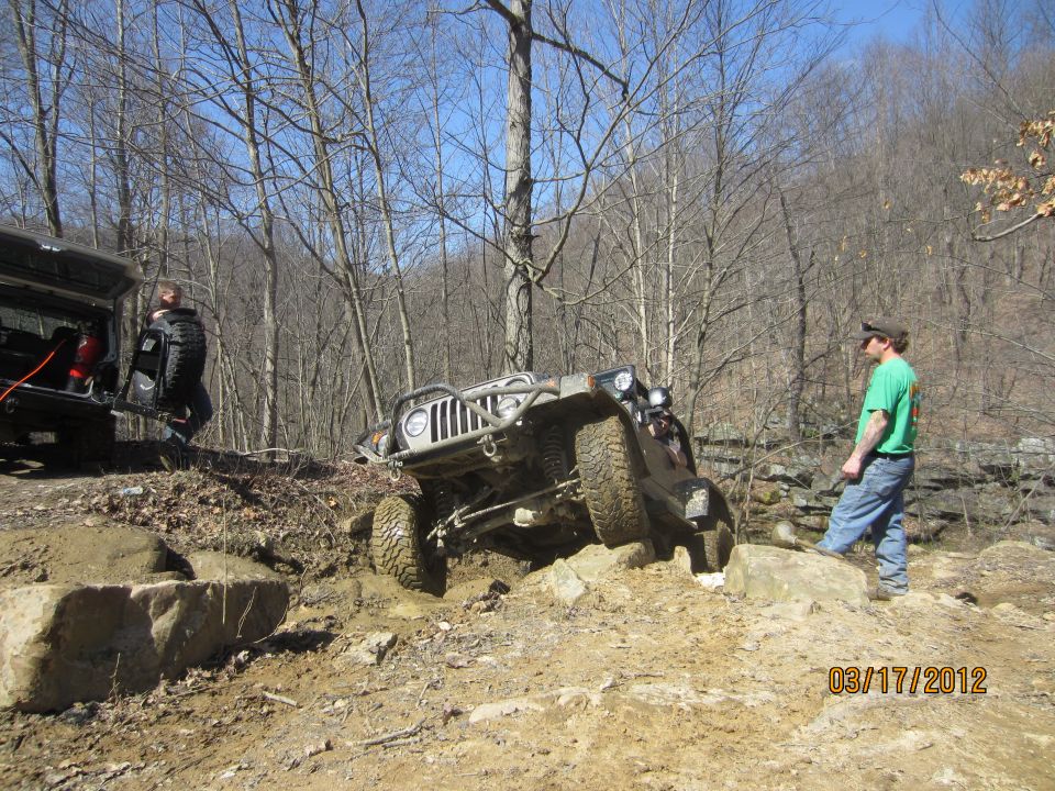 Jeep Wrangler climbing over rocks with another vehicle and people nearby. Date stamp 03/17/2012