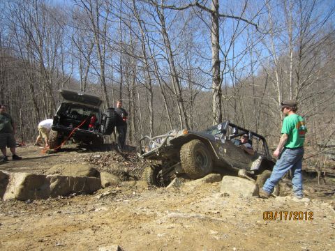 1979 Ford Bronco - Off-road enthusiasts navigate a challenging rocky trail with their vehicles, one of which appears to be stuck.