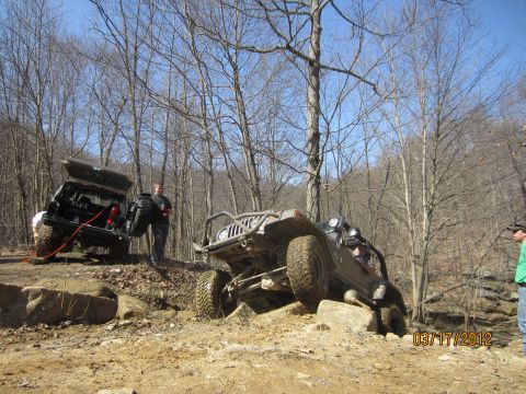 1979 Ford Bronco - Off-road vehicles tackle a challenging rocky course in a wooded area.