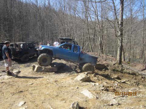 1979 Ford Bronco - Off-road vehicles tackle a challenging rocky course in a wooded area.