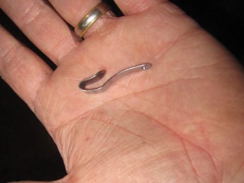 1990 Ford Bronco - A small metal clip is held in a person's hand, with a ring visible on their finger.