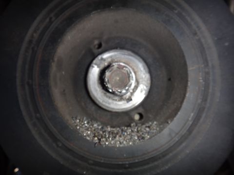 1993 Ford Taurus - Close-up view of a pulley with significant metal shavings accumulated around the central bolt.