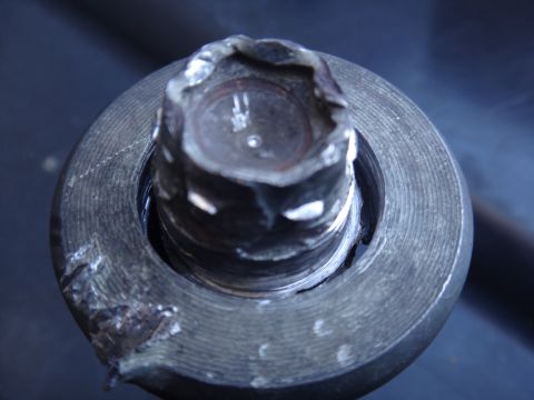 1993 Ford Taurus - Close-up view of a damaged lug nut, showing wear and deformation in its hexagonal recess.